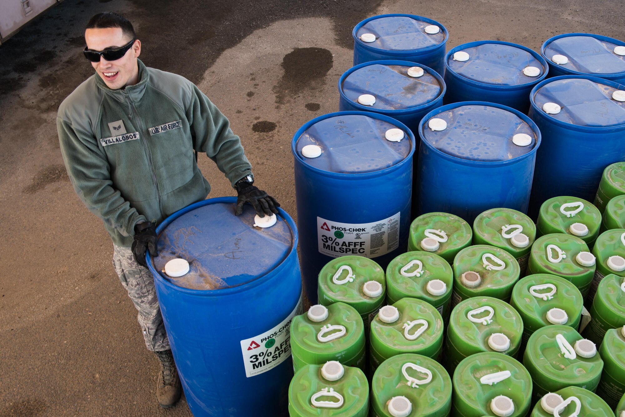 Senior Airman Francisco Villalobos, 407th Expeditionary Civil Engineer Squadron firefighter, moves a 55-gallon drum while transferring fire retardant from a foam trailer at the 407th Air Expeditionary Group, Jan. 6, 2016. The unit switched all the fire retardant foam in their inventory as part of an Air Force-wide initiative to use more environmentally friendly foam. (U.S. Air Force photo/Master Sgt. Benjamin Wilson)(Released)