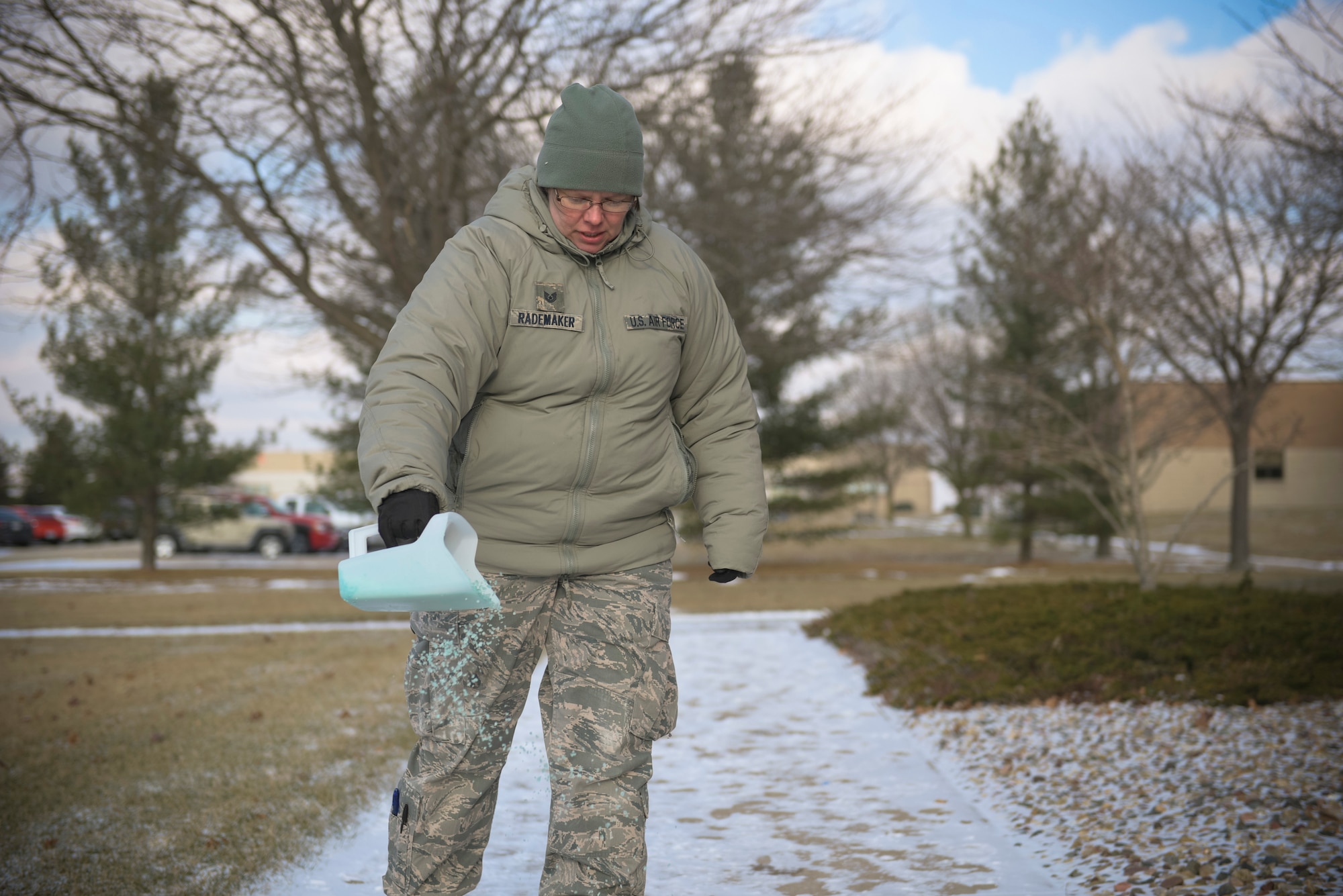 U.S. Air Force Tech. Sgt. Dawn Rademaker, a broadcast journalist craftsman with the 182nd Airlift Wing, Illinois Air National Guard, applies ice melt salt to the sidewalk in Peoria, Ill., Jan. 7, 2017. Wearing traction cleats over shoes and applying salt to sidewalks can help prevent slipping on ice, according the wing’s safety office. (U.S. Air National Guard photo by Airman 1st Class Jason Grabiec)