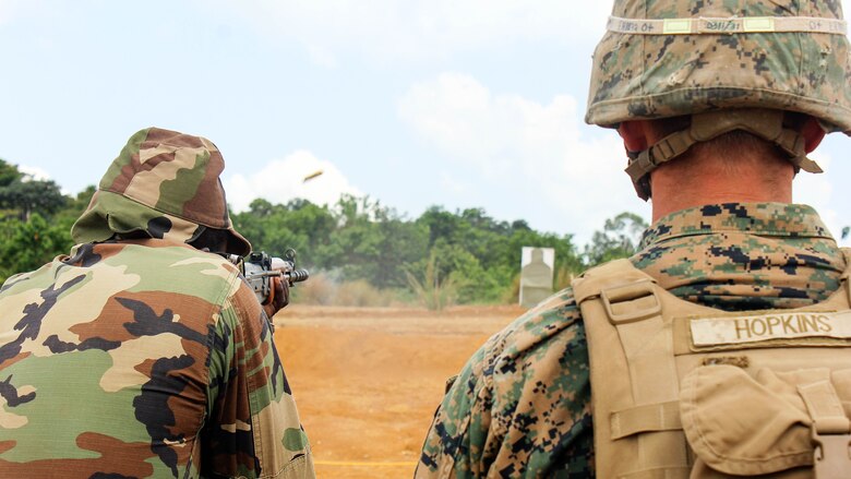 Lance Cpl. Beau Hopkins, a rifleman with Special Purpose Marine Air-Ground Task Force Crisis Response-Africa, watches a Gabonese Armed Forces soldier fire his AK-47 at a paper target during a range at Camp Mokekou, Gabon, Nov. 24, 2016. Marines trained together with the Gabonese Agency for National Parks and Gabonese Armed Forces to help combat illicit trafficking in the region. 