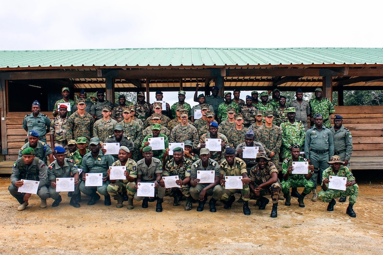 Marines with Special Purpose Marine Air-Ground Task Force Crisis Response-Africa, pose for a group photo with Gabonese Armed Forces soldiers after a graduation ceremony at Camp Mokekou, Gabon, Dec. 8, 2016. Marines taught classes and trained with the Gabonese Agency for National Parks and Gabonese Armed Forces to help combat illicit trafficking in the region. 