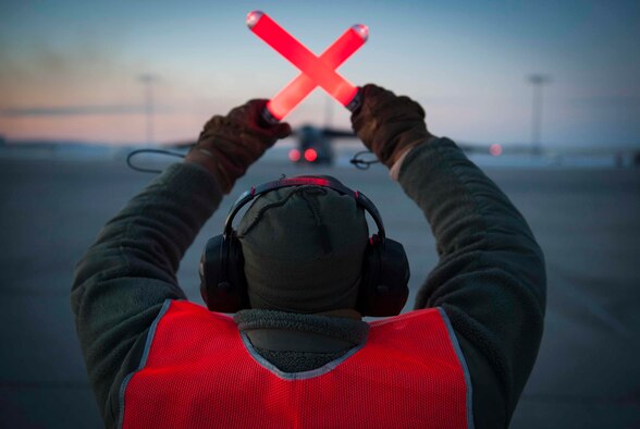 Senior Airman Taylor Lancaster, a 5th Aircraft Maintenance Squadron aircraft crew chief, guides a B-52H Stratofortress on Minot Air Force Base, N.D., Jan. 9, 2015. Lancaster’s main duty is to ensure his jet is fixed and prepared to take off before its flight time. (U.S. Air Force photo/Airman 1st Class Sahara L. Fales)