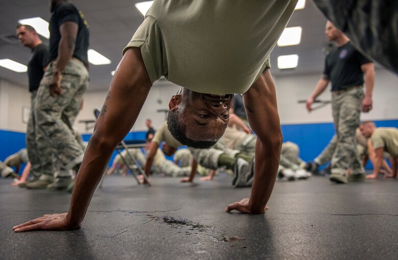 Staff Sgt. Christopher Maire, a 60th Security Forces Squadron patrolman at Travis Air Force Base, Calif., strains to complete an exercise during a physical training session Jan. 5, 2016, during the first week of the Phoenix Raven Qualification Course at Joint Base McGuire-Dix-Lakehurst, N.J. The intensive three-week, 12-hour-a-day course covers such subjects as cross-cultural awareness, legal considerations, embassy operations, airfield survey techniques, explosive ordnance awareness, aircraft searches and unarmed self-defense techniques. (U.S. Air Force photo/Staff Sgt. Vernon Young Jr.)