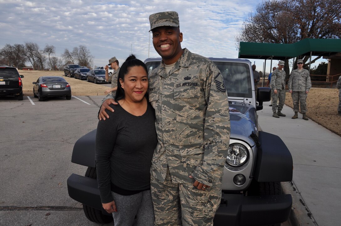 Master Sgt. Steven Pruitt and his wife, Joann, stand in front of their new 2017 Jeep Wrangler, the grand prize in the Air Force Services Activity's Air Force Club Membership Giveaway, at Tinker Air Force Base, Oklahoma, Dec. 21, 2016. Col. Donna L. Turner, AFSVA commander, presented the keys at Pruitt’s squadron commander’s call. Pruitt, the NCO in charge of the Cyber Security Office, 552nd Air Control Network Squadron, entered the giveaway 20 times; his name was randomly generated from more than 11,000 entries. (U.S. Air Force photo by Annette Crawford)