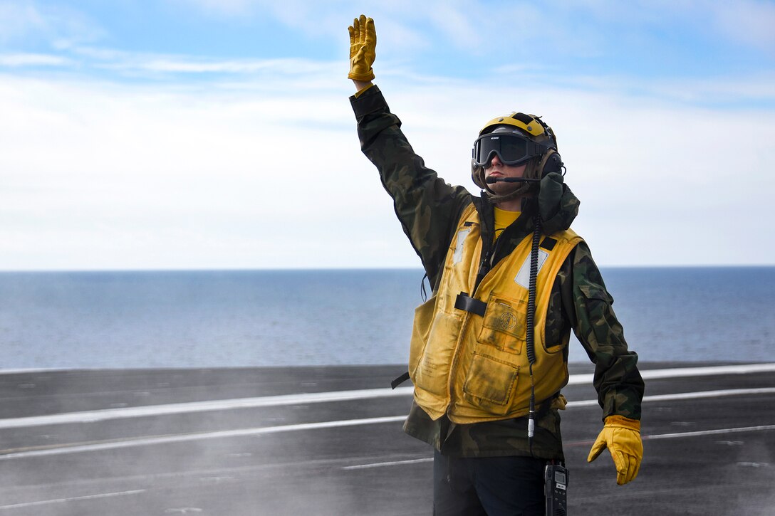 Navy Petty Officer 3rd Class Dylan Mills directs an E-2C Hawkeye on the flight deck of the aircraft carrier USS Carl Vinson in the Pacific Ocean, Jan. 5, 2017. Mills is an aviation boatswain's mate, handling. Navy photo by Petty Officer 2nd Class Sean M. Castellano