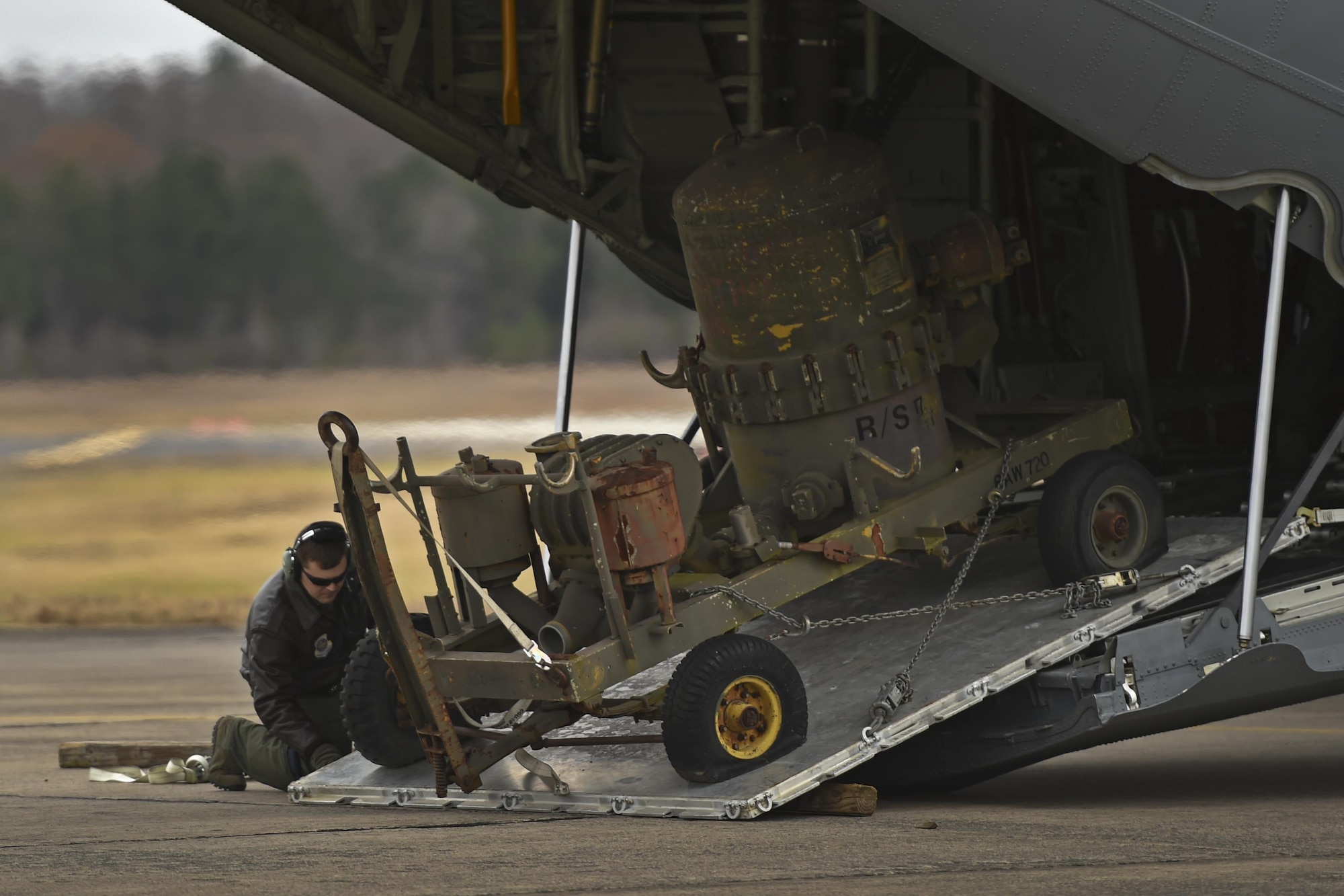 U.S. Air Force Staff Sgt. Casey Strauss, 61st Airlift Squadron C-130J loadmaster, simulates a Method A Combat Offload of a fuel filter separator during a deployment training exercise Dec 7, 2016 at Little Rock Air Force Base, Ark. Method A Combat Offloads are often utilized in locations where there are no vehicles or equipment to assist in offloading supplies. (U.S Air Force photo by Senior Airman Harry Brexel)