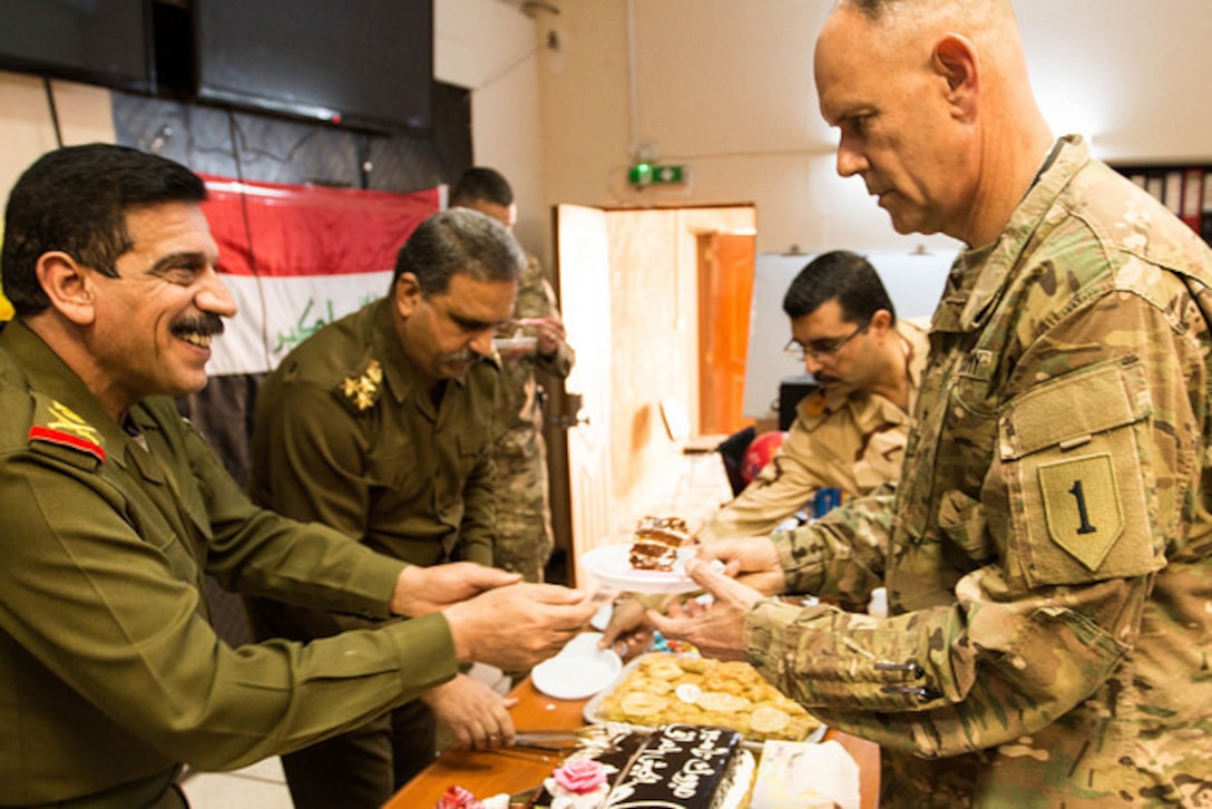 Maj. Gen. Ahmed Abid Al-Nak Said, director of the Combined Joint Operation Center – Baghdad, presents a slice of cake to Brig. Gen. William Turner, deputy commanding general, Combined Joint Forces Land Component Command – Operation Inherent Resolve, during the Iraqi Armed Forces Day celebration on Jan. 6 on Union III, Baghdad, Iraq. Iraqi Armed Forces Day commemorates the activation of the Iraqi Army on Jan. 6, 1921. (Photo by U.S. Army Spc. Derrik Tribbey)