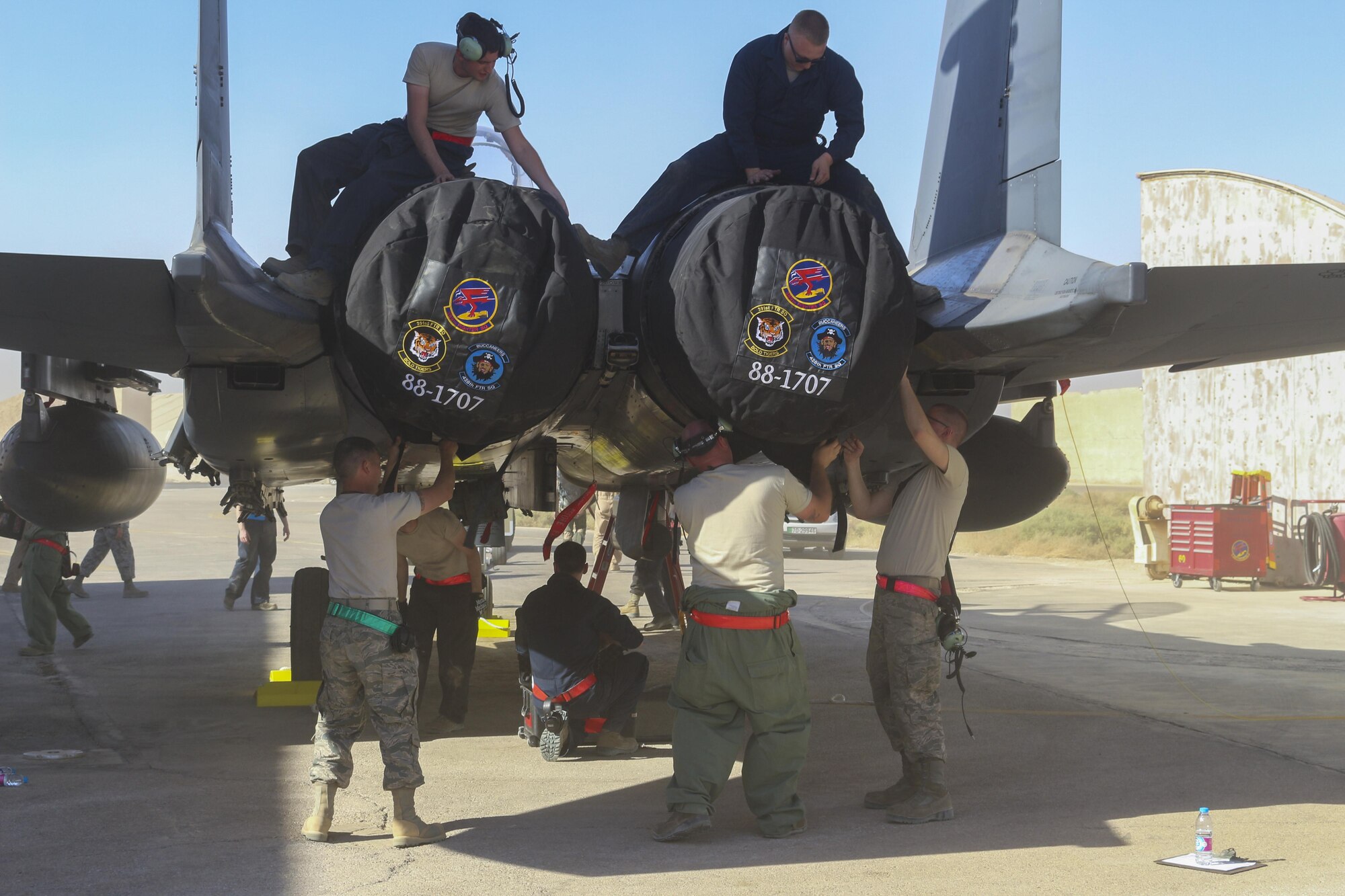 Airmen assigned to the 366th Fighter Wing cover an F-15E Strike Eagle's exhaust vents in an undisclosed location in Southwest Asia, October 5th, 2016. The F-15's dual engines provide redundency, allowing the pilot to remain in control in case of engine failure.(Courtesy Photo)