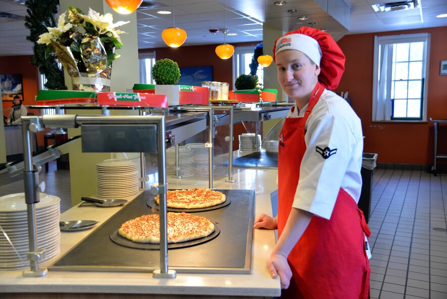 Airman Candace Ellenburg, 90th Force Support Squadron food services apprentice, poses next her favorite station in Chadwell dining facility at F. E. Warren Air Force Base, Wyo., Dec. 17, 2016. Ellenburg is an eager food service Airman always willing to lend a hand and improve her culinary skills. (U.S. Air Force phot by 2nd Lt. Nikita Thorpe)