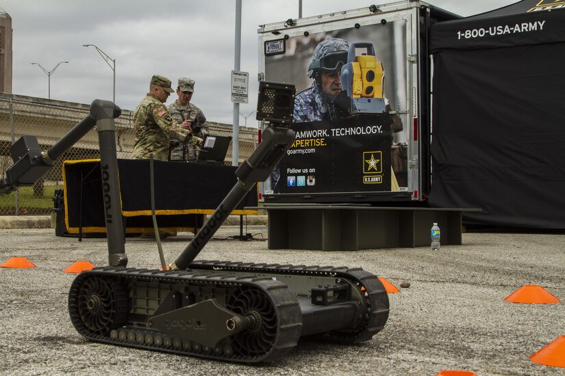 U.S. Army Sgt. 1st Class Richard Sullins (left), an exhibitor assigned to the U.S. Army Mission Support Battalion’s Mobile Exhibit Company, Fort Knox, Ky., demonstrates the capabilities of an iRobot Packbot to U.S. Army Reserve Sgt. Andrew Carroll, a broadcast journalist assigned to the 367th Mobile Public Affairs Detachment, 318th Press Camp Headquarters, Columbus, Ohio, at the Go Army Experience outside the San Antonio Alamodome, Jan. 5 as part of events leading up to the 2017 U.S. Army All-American Bowl (AAB). The Mobile Exhibit Company travels the country interacting with the American public to reconnect America’s people with America’s Army. The AAB will be broadcast live on NBC Jan. 7 at 12 p.m. CDT. (U.S. Army Reserve photo by Spc. James Lefty Larimer, 367th Mobile Public Affairs Detachment)
