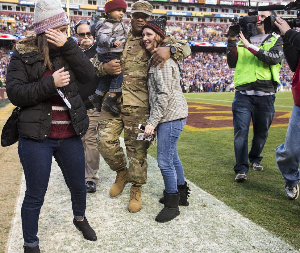 Jessica L. Watkins (left) wipes off her tears as her husband Spc. Leo Watkins Jr., a U.S. Army Reserve military police Soldier with the 372nd Military Police Company in Cumberland, Maryland, holds his youngest son during a surprise homecoming during the Washington Redskins game against the New York Giants at FedEx Field in Landover, Maryland, Jan. 1. The Martinsburg, West Virginia native has spent the last ten months in Guantanamo Naval Base, Cuba. 

(Photo by U.S. Army Staff Sgt. Nazly Confesor, 200th MP Command Public Affairs/Released)