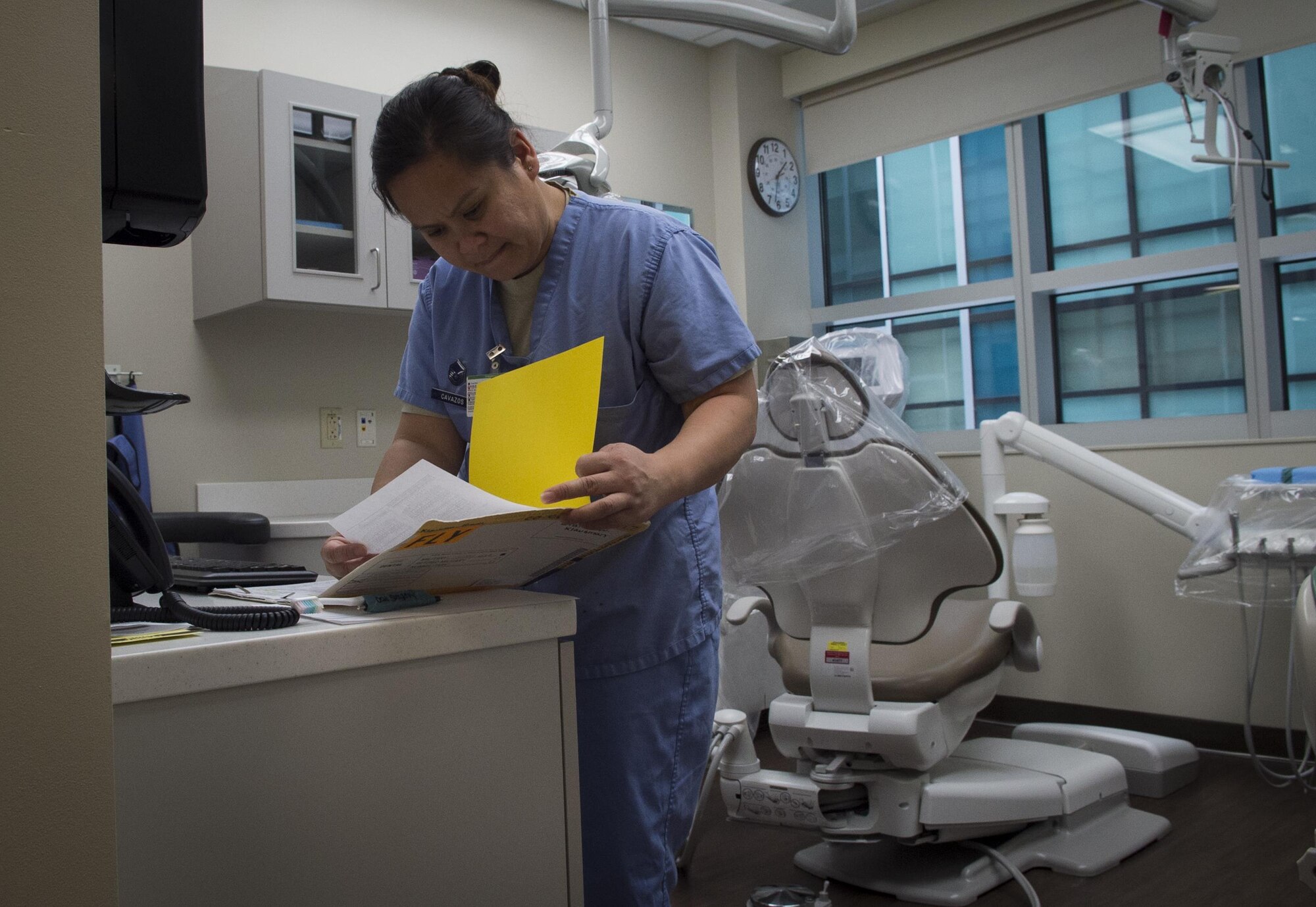 Master Sgt. Millicent Cavazos, 779th Medical Group dental squadron dental hygienist, checks over a patient’s paperwork before a dental cleaning at Joint Base Andrews, Md., Jan. 6, 2017. The dental clinic now sees patients in the new edition to Malcolm Grow Medical Clinics and Surgery Center as well as their former clinic to maximize efficiency for patients. (U.S. Air Force photo by Senior Airman Mariah Haddenham)