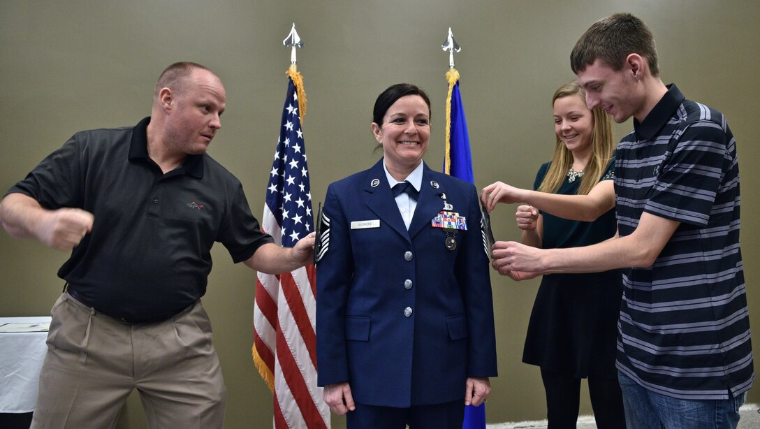 Newly promoted to Chief Master Sgt., Barbara Gilmore, 932nd Medical Squadron chief enlisted manager,  braces for impact as her husband Craig and two children assist during the pin on ceremony, Jan. 8, 2017, Scott Air Force Base, Illinois.  (U.S. Air Force photo by Tech. Sgt. Christopher Parr)