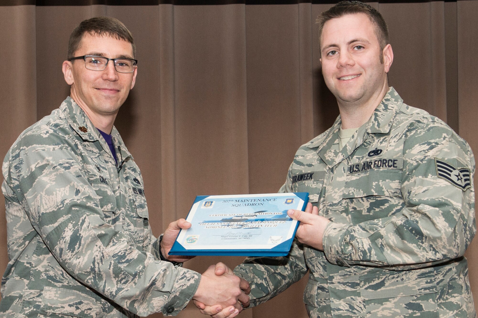 U.S. Air Force Maj. George Cole III, 307th Maintenance Squadron (MXS) commander, presents the Lt. Gen. Leo Marquez Award nominee certificate to Staff Sgt. Beau Traweek on Jan. 8, 2017, Barksdale Air Force Base, La. Traweek is assigned to the 307th MXS Propulsion Flight and was selected to compete at the Group level for an opportunity to represent the 307th Bomb Wing at the Command level. The Award is the most prestigious maintenance award give in the United States Air Force and recognizes the best of the best in performance on the job. (Master Sgt. Greg Steele/Released)