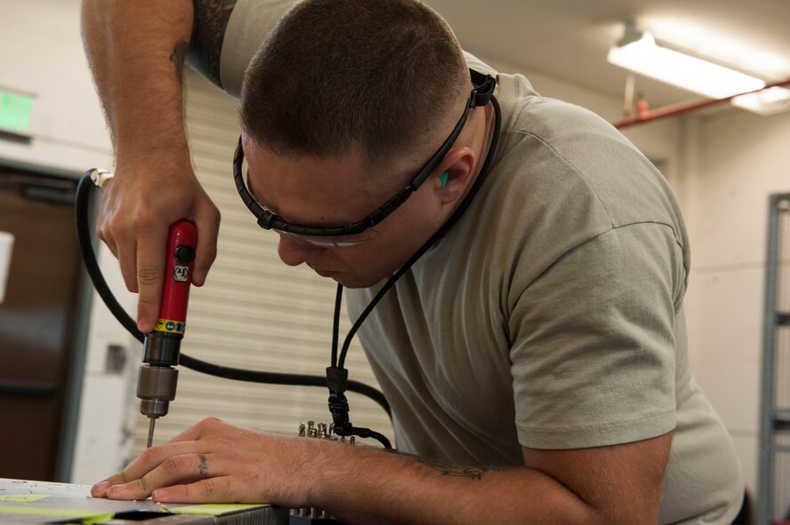 U.S. Air Force Senior Airman Taylor Dufrene, 18th Equipment Maintenance Squadron aircraft structural maintenance journeyman, drills in rivets on a simulated aircraft structure Jan. 9, 2016, at Kadena Air Base, Japan. Aircraft structural maintenance Airmen ensure structural integrity of multiple types of aircraft assigned to Kadena, including the HH-60G Pave Hawk, KC-135 Stratotanker, E-3 Sentry and other reconnaissance aircraft. (U.S. Air Force photo by Senior Airman Lynette M. Rolen/Released)