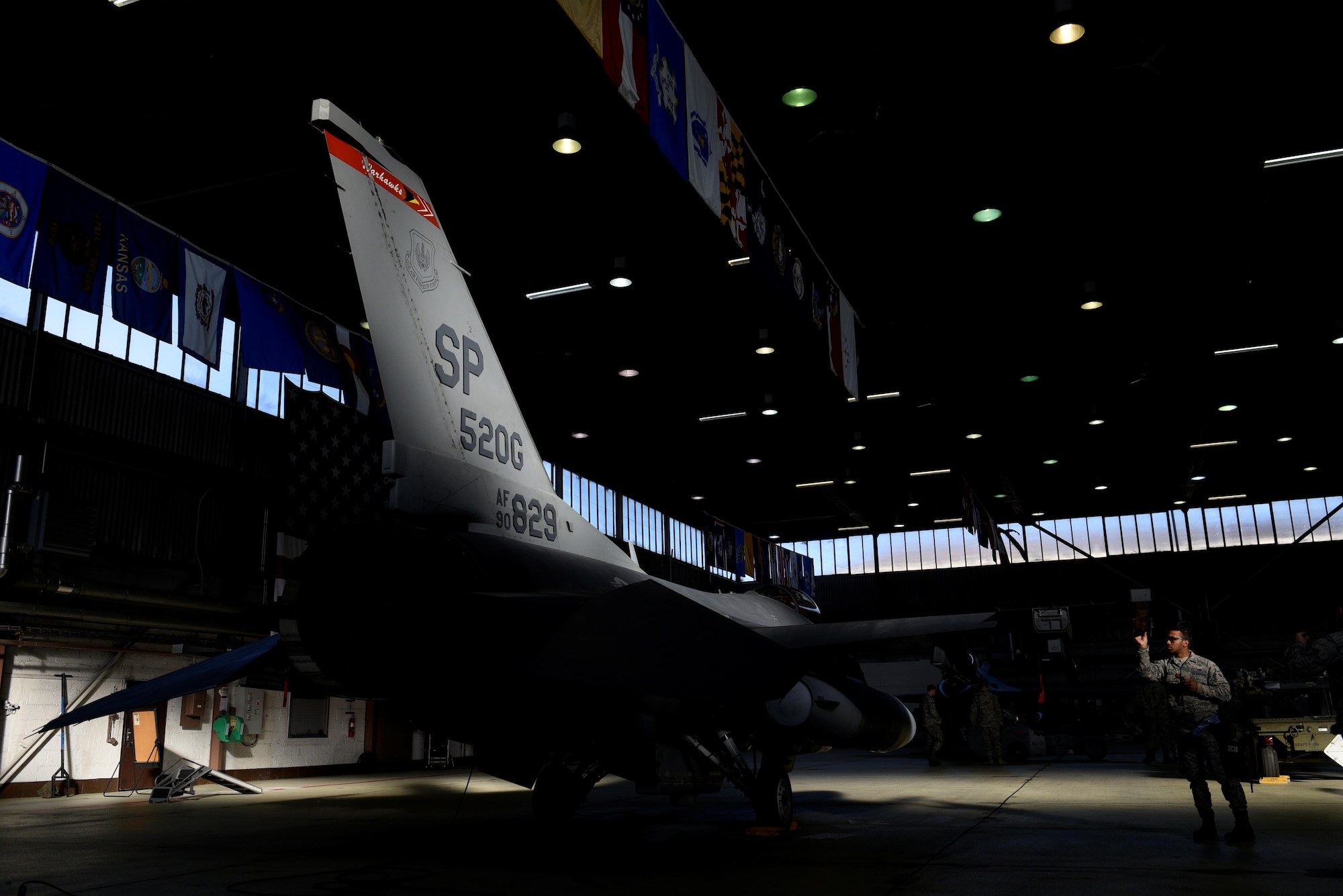 U.S. Air Force Airman 1st Class Licinio Monteiro, 52nd Aircraft Maintenance Squadron weapons load crew member, prepares an F-16 Fighting Falcon for inert weapons to be loaded during the quarterly weapons load competition in Hangar One at Spangdahlem Air Base, Germany, Jan. 6, 2017. The competition consisted of two teams competing against each other to load weapons quickly and accurately. (U.S. Air Force photo by Staff Sgt. Jonathan Snyder)