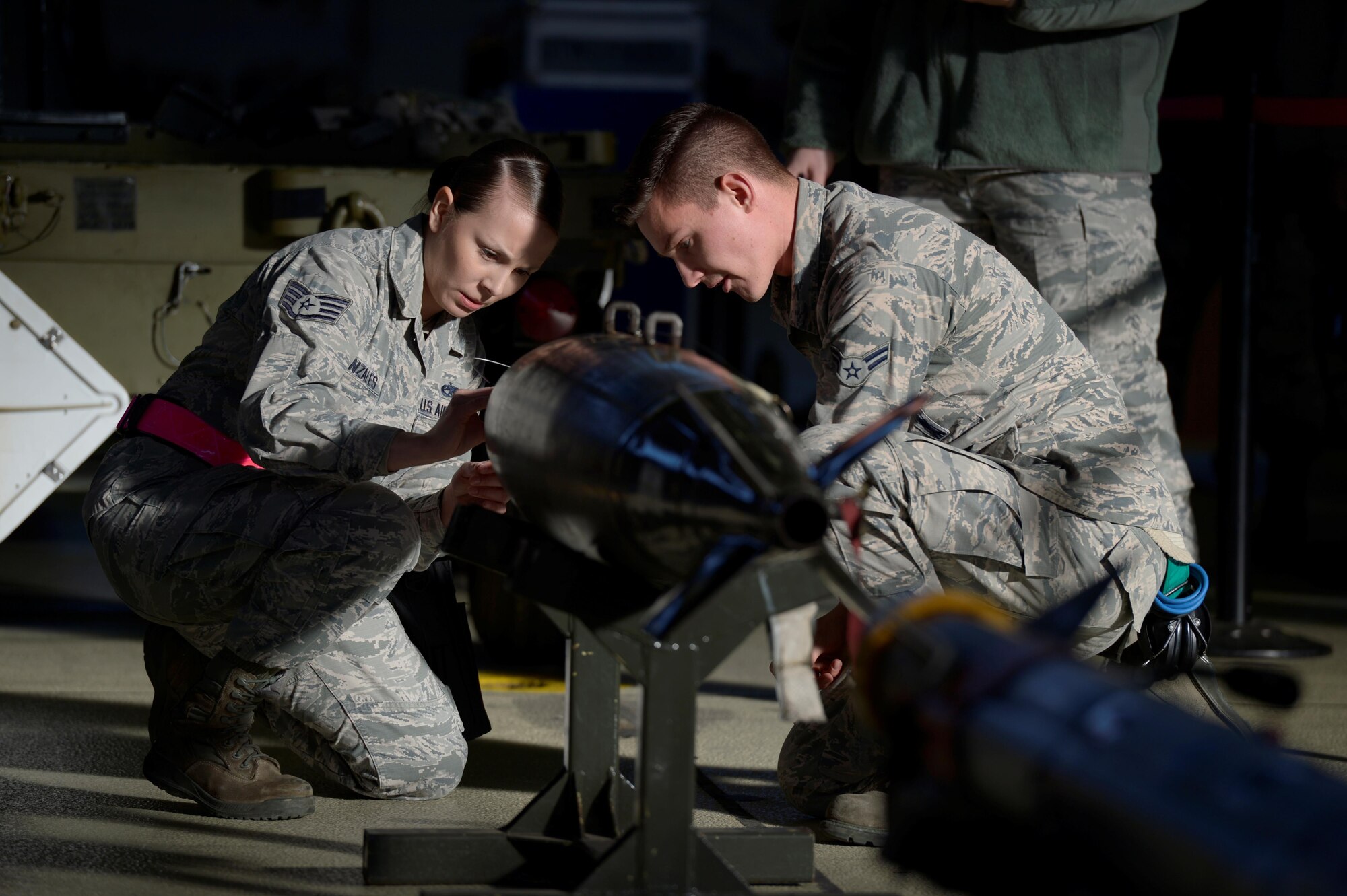 U.S. Air Force Staff Sgt. Sarah Gonzales, left, 52nd Aircraft Maintenance Squadron weapons load crew chief, and
Airman 1st Class Joshua Reeves, right, 52nd AMXS weapons load crew member, prepares an inert weapon to be
loaded on an F-16 Fighting Falcon during the quarterly weapons load competition in Hangar One at Spangdahlem
Air Base, Germany, Jan. 6, 2017. The competition consisted of two teams competing against each other to load
weapons quickly and accurately. (U.S. Air Force photo by Staff Sgt. Jonathan Snyder)