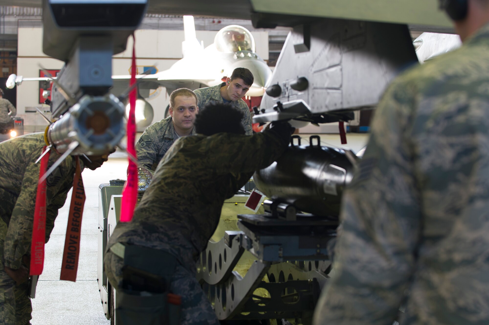 52nd Fighter Wing evaluators observe Staff Sgt. DeAnte Miller and Senior Airman Michael Curtis, both 52nd Aircraft Maintenance Squadron tactical aircraft weapons systems specialists, during the 52nd FW Load Crew of the Quarter competition at Spangdahlem Air Base, Germany, Jan. 6, 2017. Family, friends and members of the Spangdahlem community attended the competition to see which of the two teams of three maintenance Airmen would move on to the annual load competition. (U.S. Air Force photo by Senior Airman Dawn M. Weber)