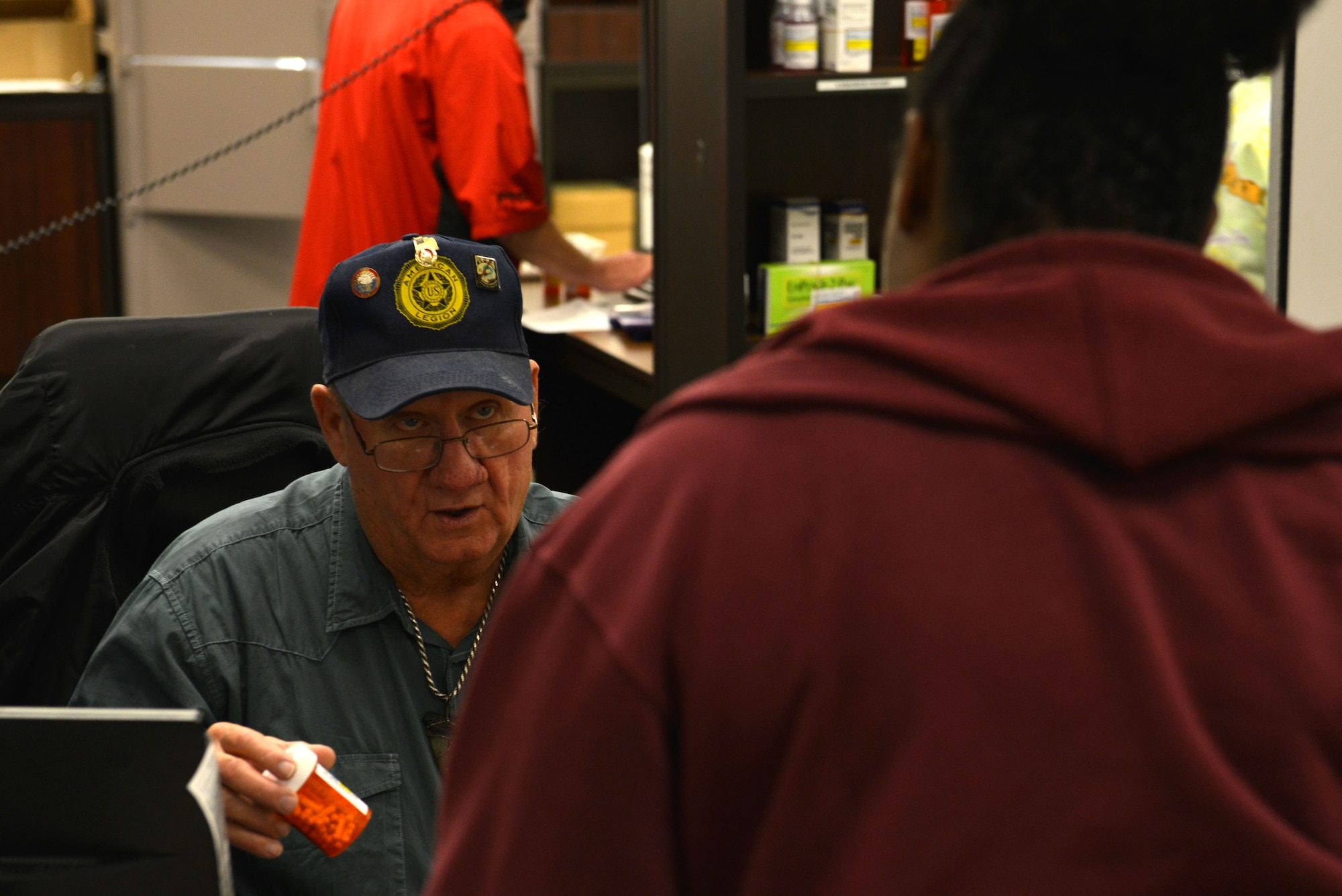 Leo Diamond, 20th Medical Support Squadron pharmacy volunteer, speaks to a customer about his medication at Shaw Air Force Base, S.C., Jan. 6, 2017. Diamond checks that the names on the prescription bottles in the customer’s paper bag match his identification before he receives them. (U.S. Air Force photo by Airman 1st Class Destinee Sweeney)