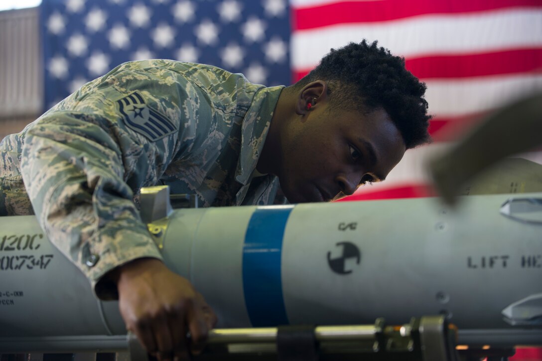 U.S. Air Force Staff Sgt. DeAnte Miller, 52nd Aircraft Maintenance Squadron tactical aircraft weapons systems specialist, prepares a dummy weapon to be loaded onto a MJ-IC jammer boom during the 52nd Fighter Wing Load Crew of the Quarter competition at Spangdahelm Air Base, Germany, Jan. 6, 2017. The load crew competition required two teams of three competing members to load weapons on to the wings of an F-16 Fighting Falcon as quickly and accurately as possible. (U.S. Air Force photo by Senior Airman Dawn M. Weber)