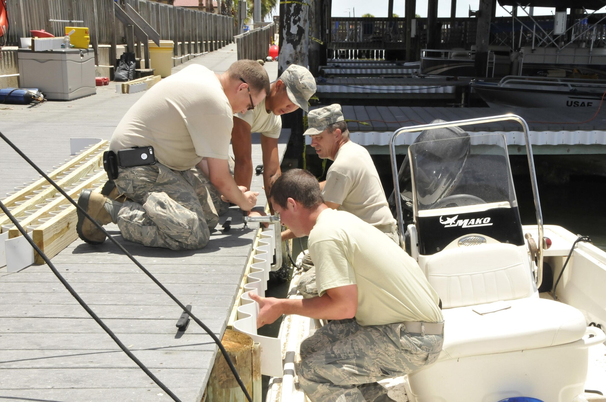 U.S. Airmen with the 181st Intelligence Wing Civil Engineering Squadron and 45th Space Wing Civil Engineering Squadron work together to install new dock fenders at the outdoor marina at Patrick Air Force Base, July 20, 2016. (U.S. Air National Guard photo by Senior Master Sgt. John S. Chapman)