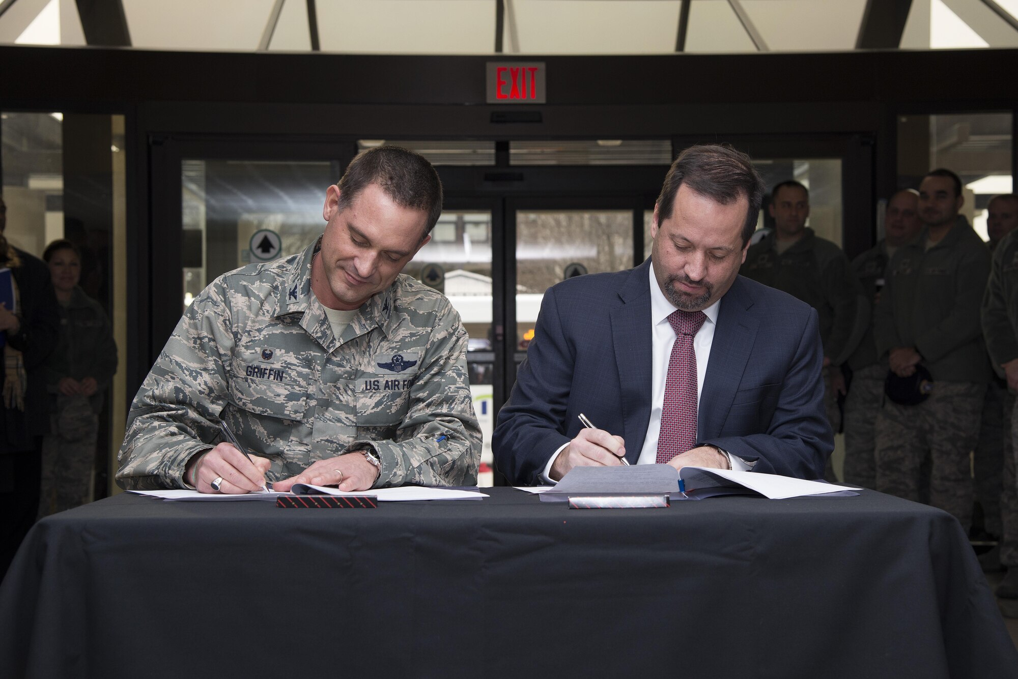 Col. Ethan Griffin, 436th Airlift Wing commander, and John Sisson, Delaware Transit Corporation CEO, sign memorandums of understanding Jan. 5, 2017, at Eagle’s Rest Inn on Dover Air Force Base, Del. The MOU commemorated the partnership that culminated in a new bus route extending onto the installation. (U.S. Air Force photo by Senior Airman Aaron J. Jenne)