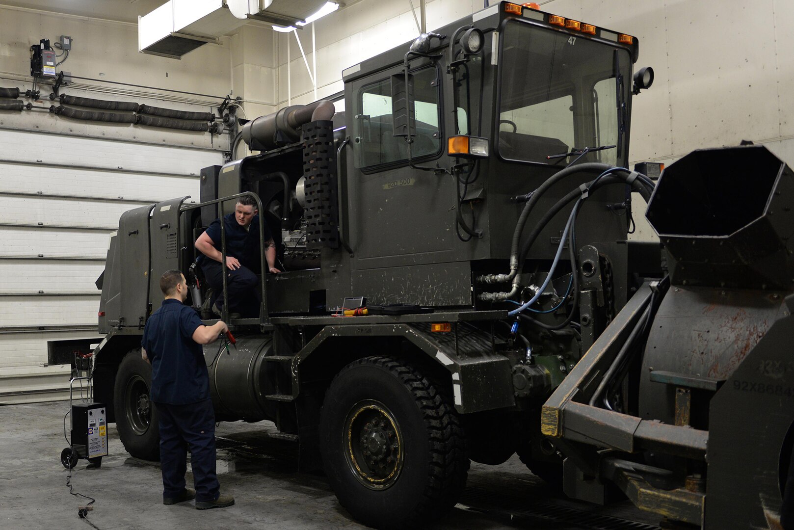 U.S. Air Force Staff Sgt. Robert Sommerfeldt and Senior Airman Dakota Greenwade, both 354th Logistics Readiness Squadron vehicle maintenance technicians, work together to pinpoint the issue with a snow blower at Eielson Air Force Base, Jan. 6, 2017.  Sommerfeldt and Greenwade ran tests on the machine to best diagnose the problem and fix it. 
