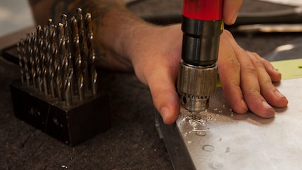 U.S. Air Force Senior Airman Taylor Dufrene, 18th Equipment Maintenance Squadron aircraft structural maintenance journeyman, drills past the head of a rivet on a simulated aircraft structure Jan. 9, 2016, at Kadena Air Base, Japan. One of the jobs of aircraft structural maintenance Airmen is replacing rivets on aircraft, making the aircraft structures mission capable. 