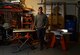 Tech. Sgt. Nicholas, 432nd Maintenance Group Quality Assurance inspector, poses for a photo Dec. 18, 2016, at his home in Las Vegas, Nev. Nicholas shares his woodworking passion by making award plaques and shadow boxes for members of Creech Air Force Base. (U.S. Air Force photo by Senior Airman Christian Clausen/Released)