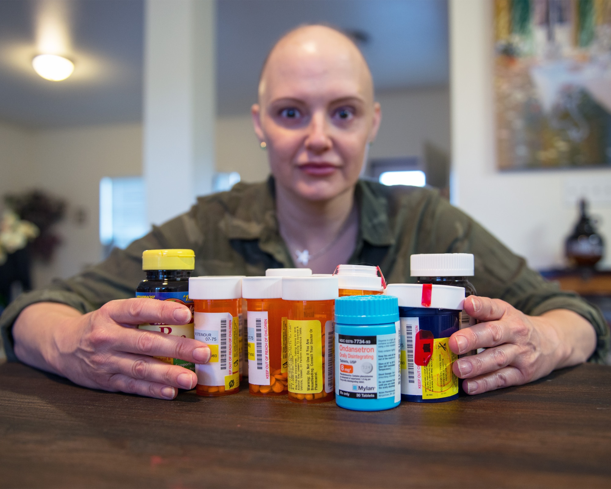 U.S. Air Force Master Sgt. Tracey Drake, 60th Medical Operations Squadron poses with her required medications, Travis Air Force Base, Calif., Jan. 10, 2017. Drake was diagnosed with metastatic breast cancer during her retirement physical in July 2016, 3 weeks before starting terminal leave. Drake faces surgery, radiation, targeted infusion, and reconstruction surgery. (U.S. Air Force photo/Louis Briscese)