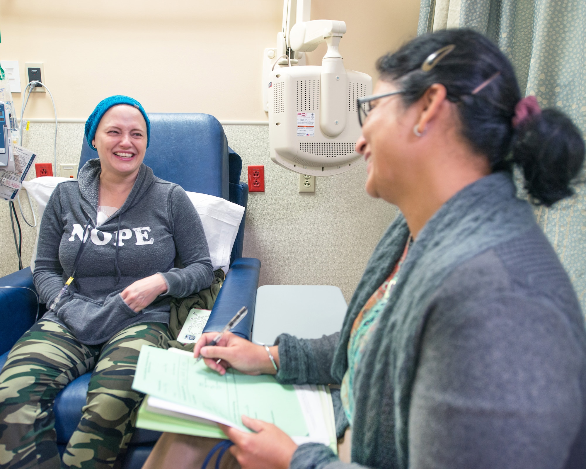 U.S. Air Force Master Sgt. Tracey Drake, 60th Medical Operations Squadron and Dr. Sareena Malhi, Hematology & Medical Oncology, enjoy a laugh before Drake is administered her chemotherapy treatment, Travis Air Force Base, Calif., Dec. 13, 2016. Drake was diagnosed with metastatic breast cancer during her retirement physical in July 2016, 3 weeks before starting terminal leave. Drake faces more chemotherapy, surgery, radiation, targeted infusion, and reconstruction surgery. (U.S. Air Force photo/Louis Briscese)