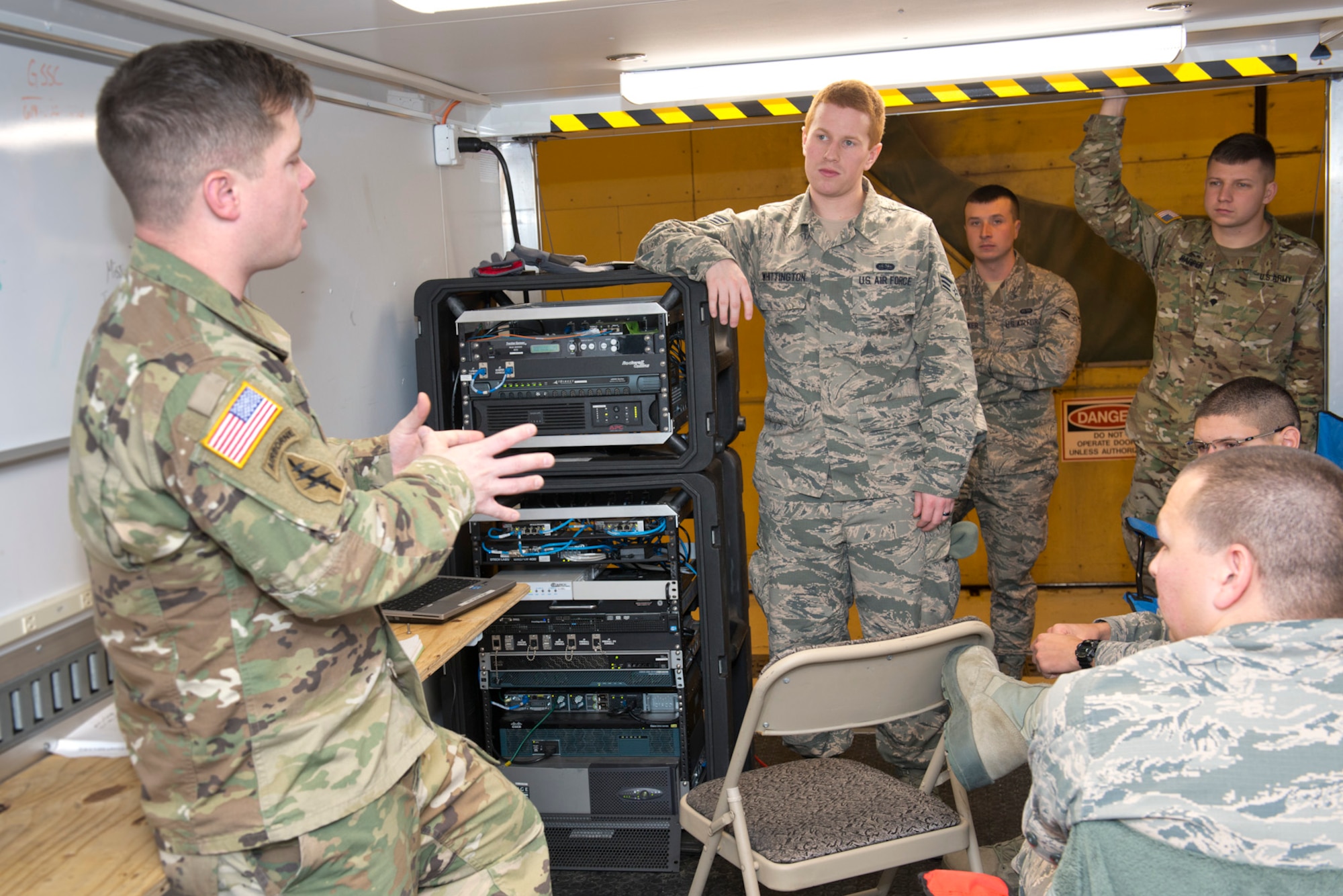 U.S. Army Staff Sgt. Michael Copen, left, a computer network technician for West Virginia National Guard Joint Force Headquarters, discusses the Joint Incident Site Communication Capability kit with U.S. Air Force Senior Airman Trevor Whittington, standing, a system administrator for the 167th Airlift Wing. JFHQ-WV signed over the JISCC to the 167th Communications Flight in December. The satellite-based communication system provides internet, telephone and radio capabilities during emergency events where normal communications may be disabled. (U.S. Air National Guard photo by Senior Master Sgt. Emily Beightol-Deyerle)
