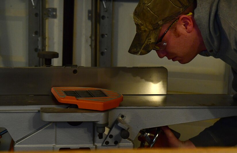 Tech. Sgt. Nicholas, 432nd Maintenance Group Quality Assurance inspector, sets his wood jointer Dec. 18, 2016, at his home in Las Vegas, Nev. Nicholas inspects maintenance during the duty-day and creates custom plaques and shadow boxes for members of Creech Air Force Base by night. (U.S. Air Force photo by Senior Airman Christian Clausen/Released)