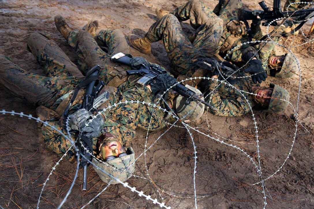 Marine Corps recruits navigate under barbed wire during Basic Warrior Training at Paige Field on Marine Corps Recruit Depot, Parris Island, S.C., Jan. 4, 2017. Basic Warrior Training is a 48 hour training evolution that covers land navigation, improvised explosive devices and fire and movement. Marine Corps photo by Lance Cpl. Sarah Stegall
