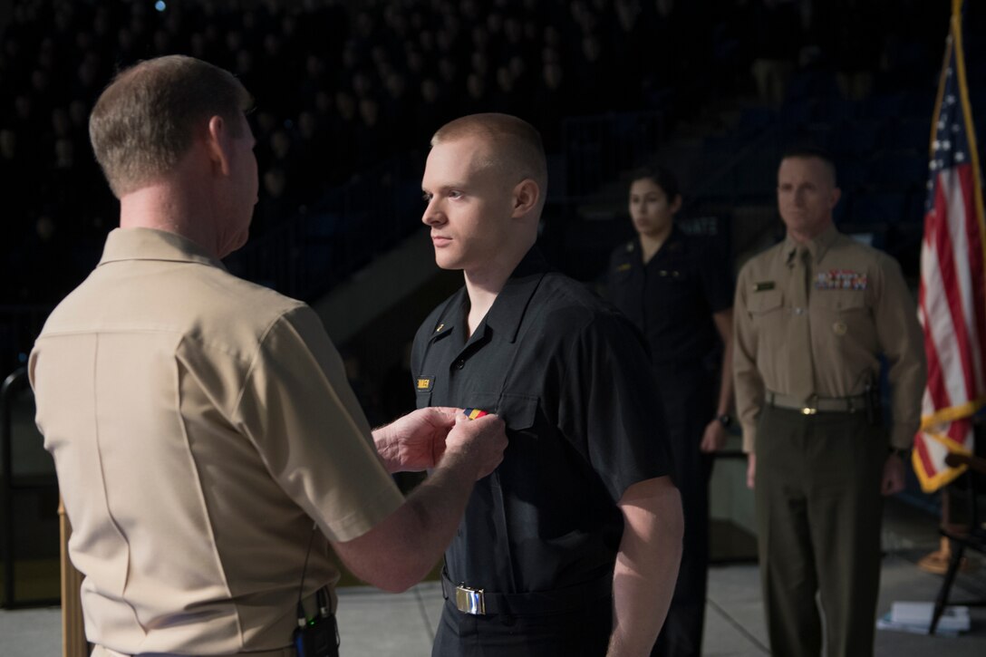 Navy Vice Adm. Ted Carter, the superintendent of the U.S. Naval Academy, left, presents the Navy and Marine Corps Medal to Midshipman 3rd Class Jonathan Dennler during a ceremony at Alumni Hall in Annapolis, Md., Jan. 9, 2017. Dennler received the medal for his heroic actions while leading a Boy Scout troop. Navy photo by Kenneth Aston 