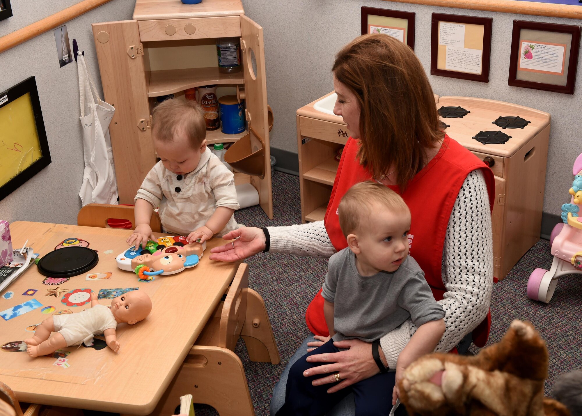 Bev Roberts, 97th Force Support Squadron Child Development Program Technician, interacts with children in a housekeeping area at the Child Development Center, January 4, 2017. The CDC provides a safe and healthy learning environment so that Department of Defense civilian and military personnel can focus on the mission knowing their children are well taken care of during the duty day.