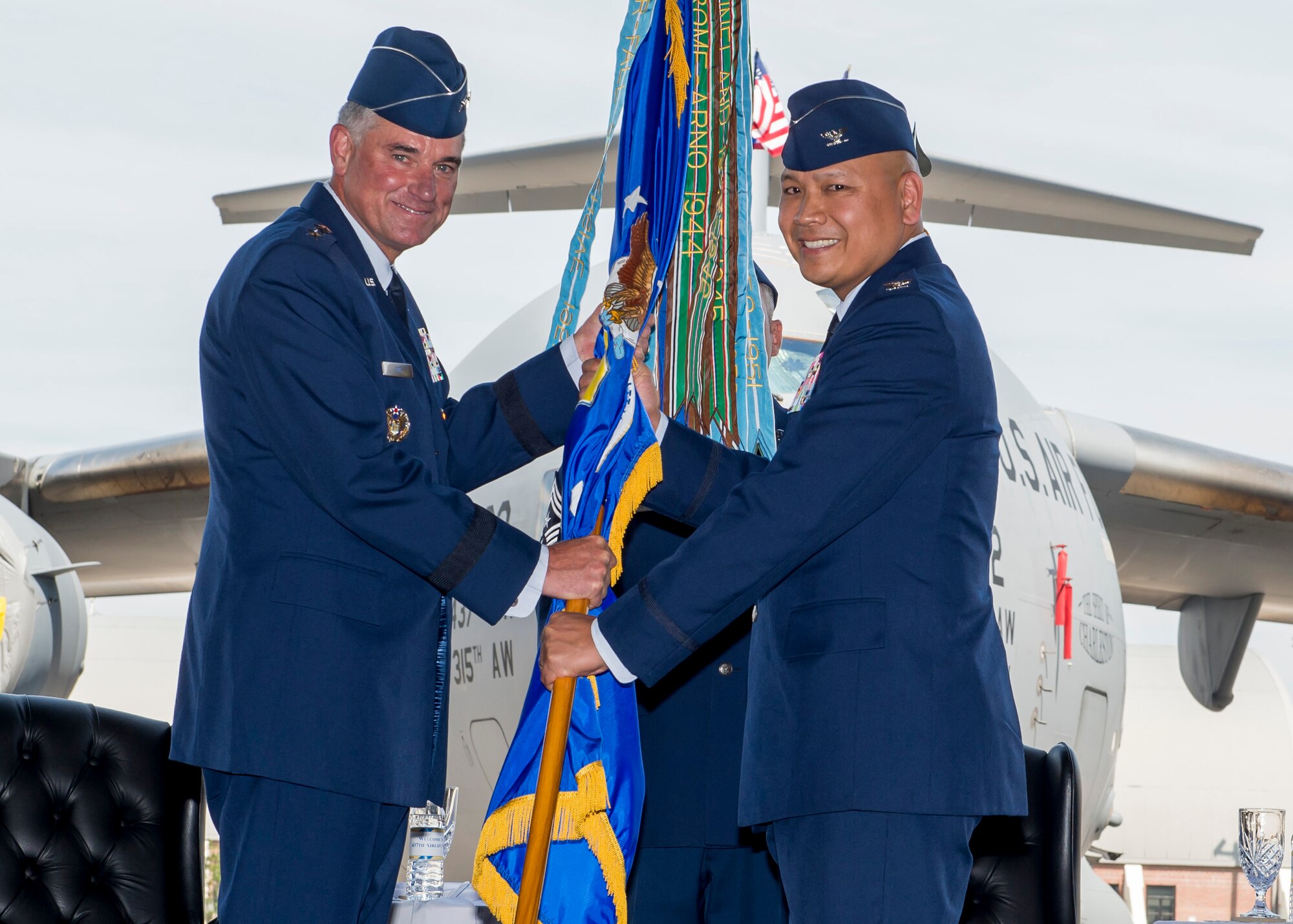 U.S. Air Force Colonel Jimmy Canlas (right) accepts the 437th Airlift Wing guidon from U.S. Air Force Lt. Gen. Samuel D. Cox, 18th Air Force commander, during the 437th AW change of command ceremony June 24, 2016 here. Now serving as the 437th Airlift Wing commander, Canlas attended the first ever Asian American and Pacific Islander forum sponsored by Presidential Commission in Washington, D.C., Dec. 5, 2016. After his father retired from the Navy, Canlas and his family moved to the Philippines from Southern California when he was eight years old. Later, Canlas returned to the U.S. to enroll in the Air Force ROTC program at the University of Texas in San Antonio, TX. (U.S. Air Force photo/Staff Sgt. Jared Trimarchi)