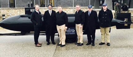 United States Navy Cmdr. Jesse J. Zimbauer (third from left) poses with Team Crane leadership in front of a model of the USS Indiana submarine during his visit to NSWC Crane on Tuesday.