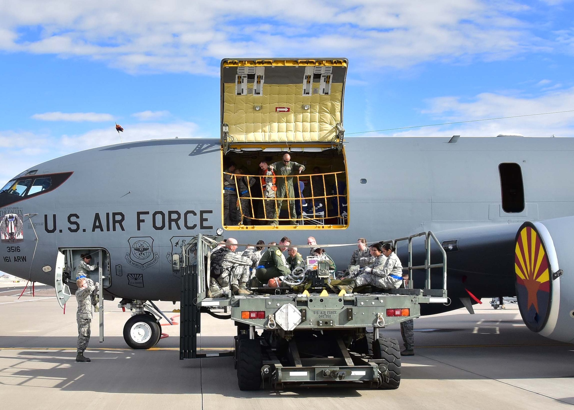 Airmen from the 161st Air Refueling Wing and 944th Aeromedical Staging Squadron work together to transport simulated patients from a K-loader to a KC-135 Jan. 7 during a joint patient movement training exercise at Goldwater Air National Guard Base, Ariz. (U.S. Air Force photo by Tech. Sgt. Louis Vega Jr.)