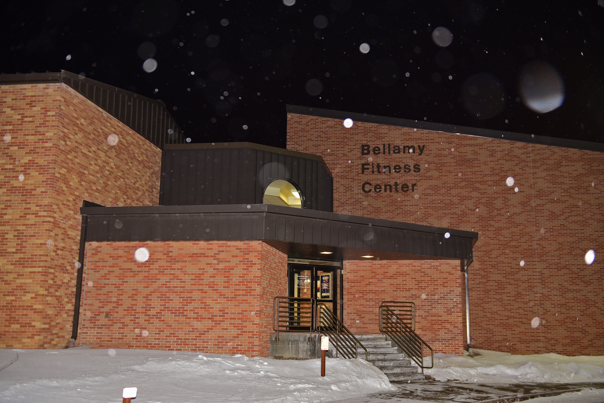 The Bellamy Fitness Center waits for patrons to walk through its doors on a snowy night at Ellsworth Air Force Base, S.D., Jan. 10, 2017. The fitness center is open 24 hours a day and access is available to all military members, spouses and dependents. (U.S. Air Force photo by Airman 1st Class James L. Miller)
