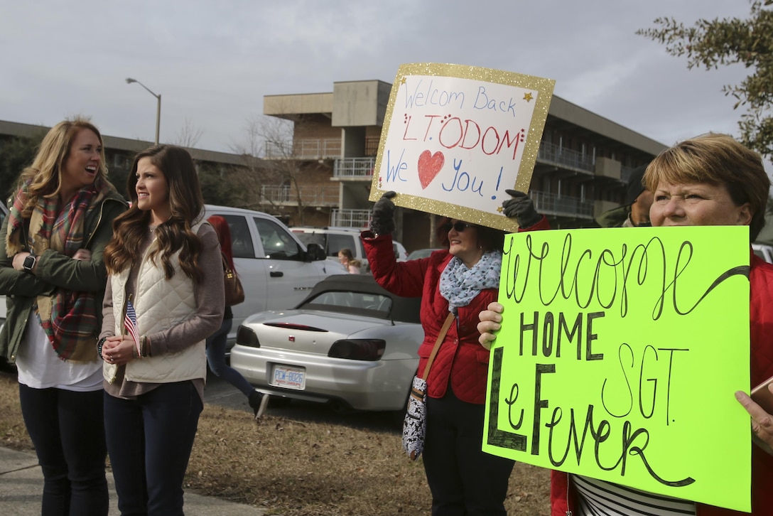 Family and friends of Marines and sailors hold up their signs as the buses carrying their loved ones arrive at Camp Lejeune, N.C., Jan. 10, 2017. Marines and sailors returned after completing the mission of protecting U.S. personnel, property and interests in Europe and Africa as part of a nine-month deployment with Special Purpose Marine Air-Ground Task Force Crisis Response-Africa. The Marines and sailors arriving are with Combat Logistic Battalion 2. (U.S. Marine Corps photo by Lance Cpl. Miranda Faughn)