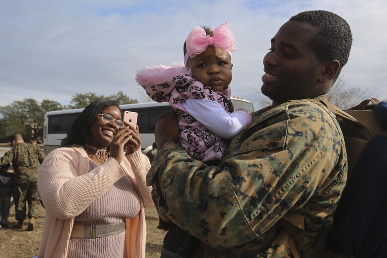 A sailor holds his daughter for the first time at a homecoming at Camp Lejeune, N.C., Jan. 10, 2017. Marines and sailors with Special Purpose Marine Air-Ground Task Force Crisis Response-Africa returned home after completing the mission of protecting U.S. personnel, property and interests in Europe and Africa. The Marines and sailors returning are with Combat Logistics Battalion 2. (U.S. Marine Corps photo by Lance Cpl. Miranda Faughn)