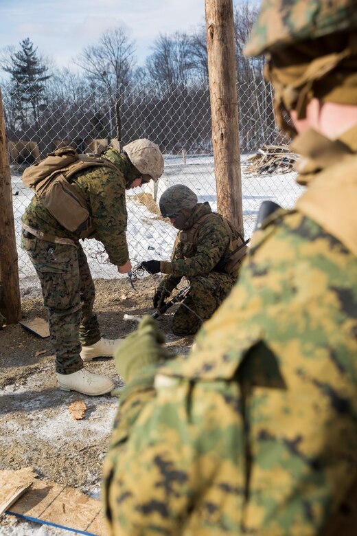 Marines with Weapons Company, 3rd Battalion, 25th Marine Regiment, 4th Marine Division, prepare a fence charge during exercise Nordic Frost at Camp Ethan Allen Training Site in Jericho, Vt., Jan. 7. 2017. The Marines were evaluated on their ability to successfully operate demolitions in a demanding cold-weather environment. (U.S. Marine Corps photo by Cpl. Melissa Martens/ Released)