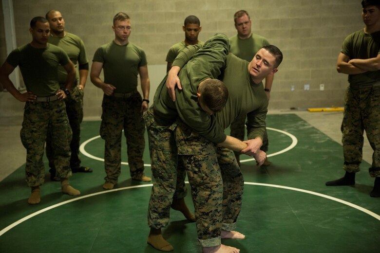 JERICHO, Vt.—Gunnery Sgt. Brandon D. Harris (center), assistant operations chief, Headquarters and Service Company, 3rd Battalion, 25th Marine Regiment, 4th Marine Division, and a black-belt martial arts instructor/trainer, demonstrates how to properly conduct a hip throw during a MCMAP course at exercise Nordic Frost at Camp Ethan Allen Training Site in Jericho, Vt., Jan. 8. 2017. Marines were provided the opportunity to obtain their grey or green belts during the exercise. (U.S. Marine Corps photo by Cpl. Melissa Martens/ Released) 