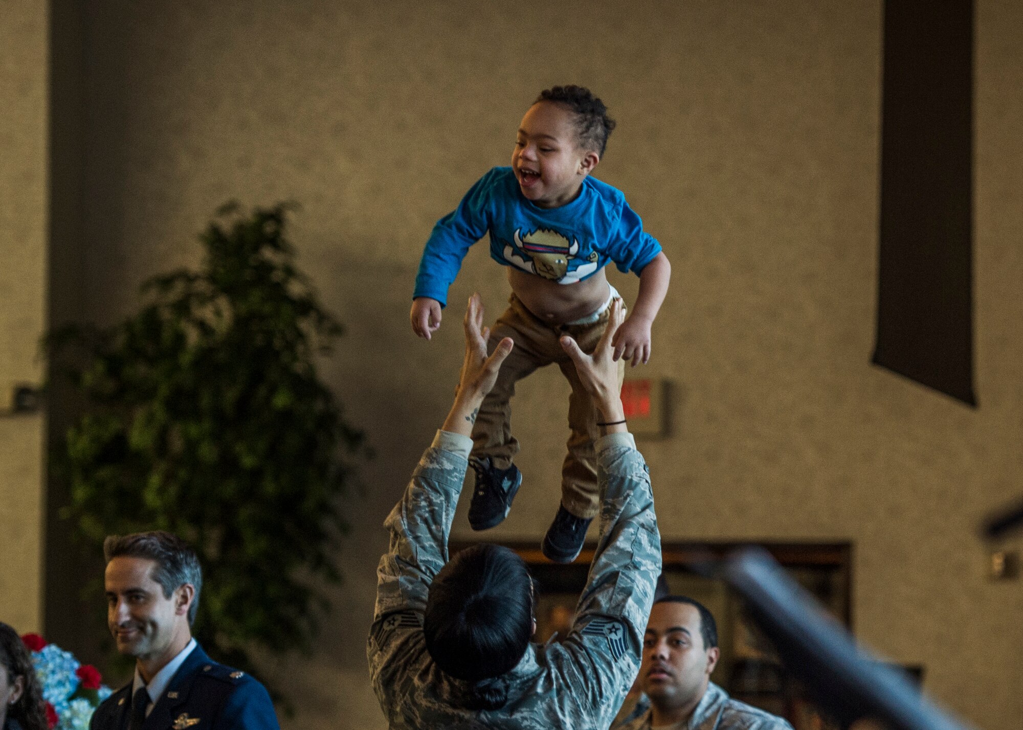 Staff Sgt. Corbyn Baggett, 618th Air Operations Center weather forecaster, tosses her 2-year-old son Gavin in the air during the kickoff.  (U.S. Air Force photo by Staff Sgt. Jodi Martinez)