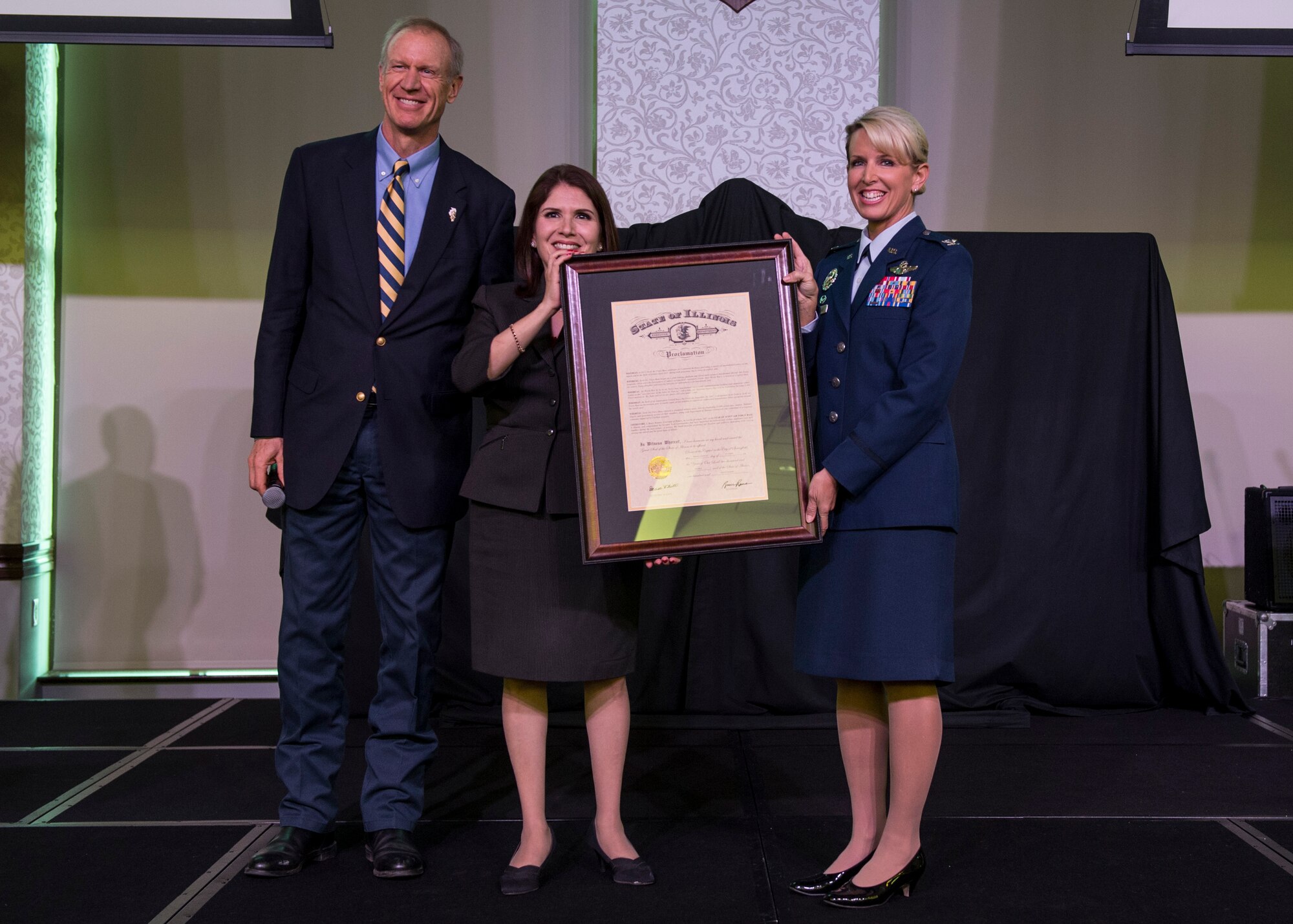 Bruce Rauner, Governor of Illinois, proclaims 2017 as the Year of Scott Air Force Base in Illinois, while Lt. Governor Evelyn Sanguinetti and Col. Laura Lenderman, 375th Air Mobility Wing commander, hold the proclamation, Scott Air Force Base, Ill. Jan. 6, 2017.  Rauner also congratulated Scott communities who have supported the military and civilian employees and their families during the past “Century of Service.” (U.S. Air Force photo by Staff Sgt. Jodi Martinez)