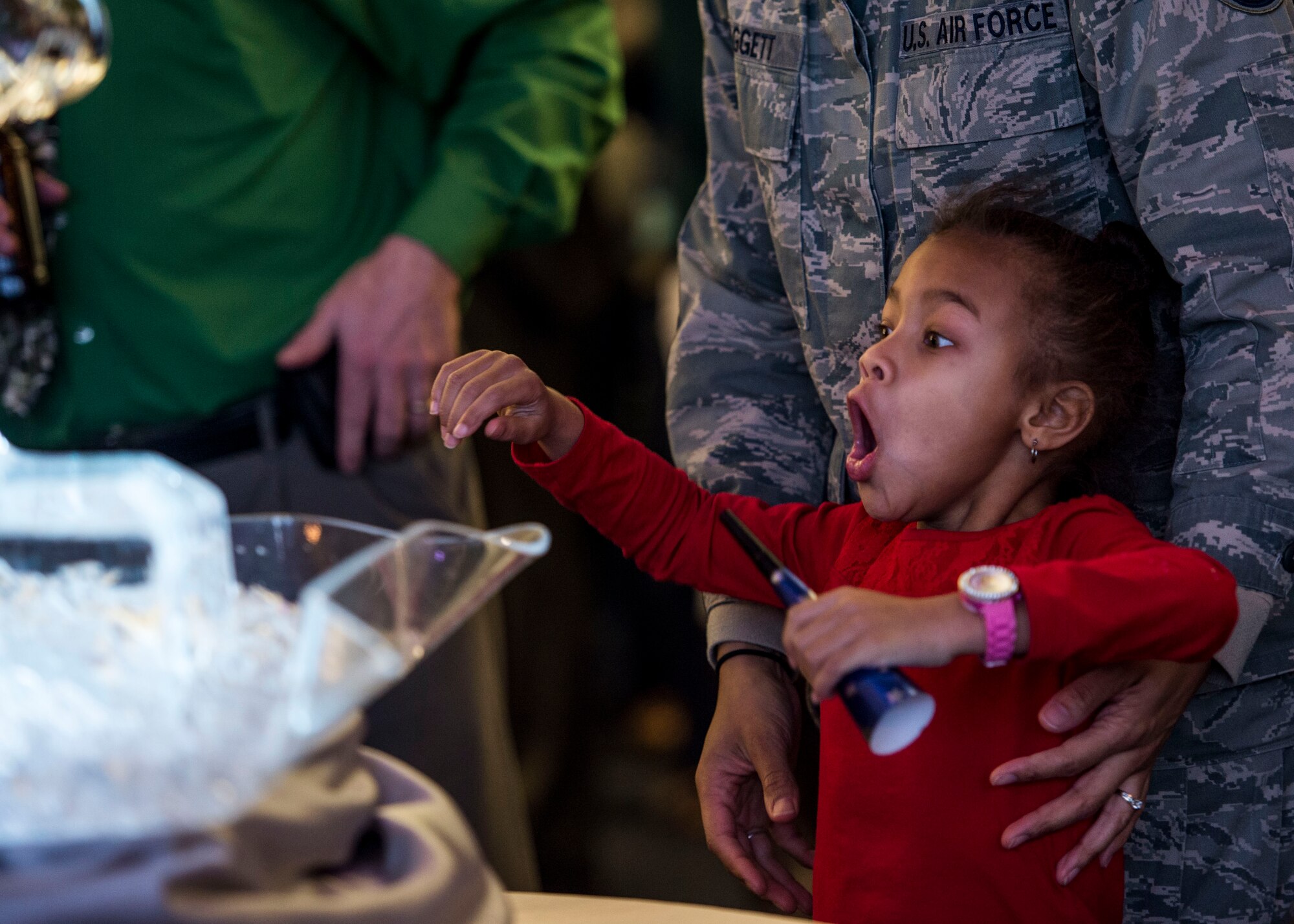 Five-year-old Devyn Baggett, daughter of Staff Sgt. Justin Baggett and Staff Sgt. Corbyn Baggett, reacts to the ice sculpture at the Centennial kickoff.  (U.S. Air Force photo by Staff Sgt. Jodi Martinez)
