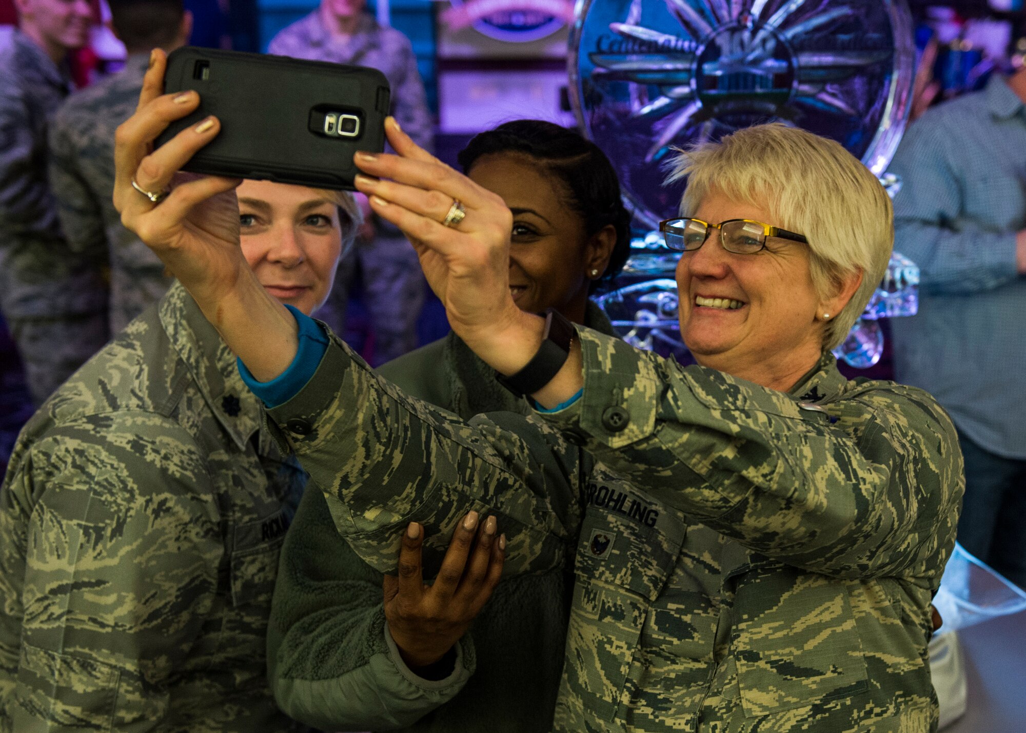 Lt. Col. Lee Rickard, 375th Medical Operations Squadron, Capt. Sonata Waller, 375th Medical Support Squadron, and Col. Colleen Frohling, 375th Medical Group, take a selfie in front of the event’s ice sculpture during the Centennial kick-off, Jan. 6, 2017.  (U.S. Air Force photo by Staff Sgt. Jodi Martinez)