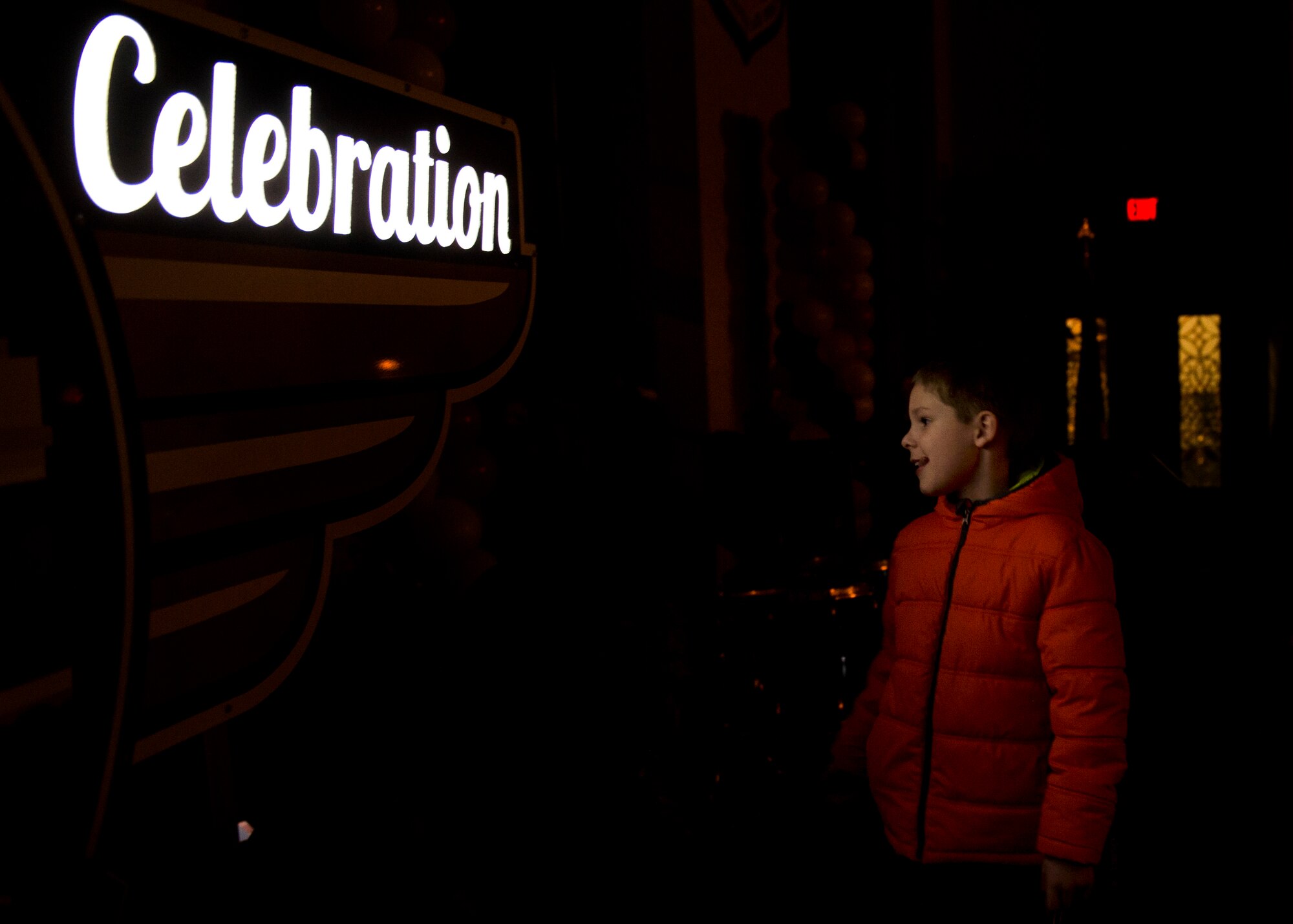 An attendee watches the firework finale at the kickoff celebration near the Centennial signage at the Scott Event Center, Scott Air Force Base, Ill., Jan. 6, 2017. Over 500 people attended the celebration, which marked the beginning of events leading up to the largest public event this summer--the airshow and open house on June 10-11 featuring the USAF Thunderbirds. (U.S. Air Force photo by Staff Sgt. Jodi Martinez)