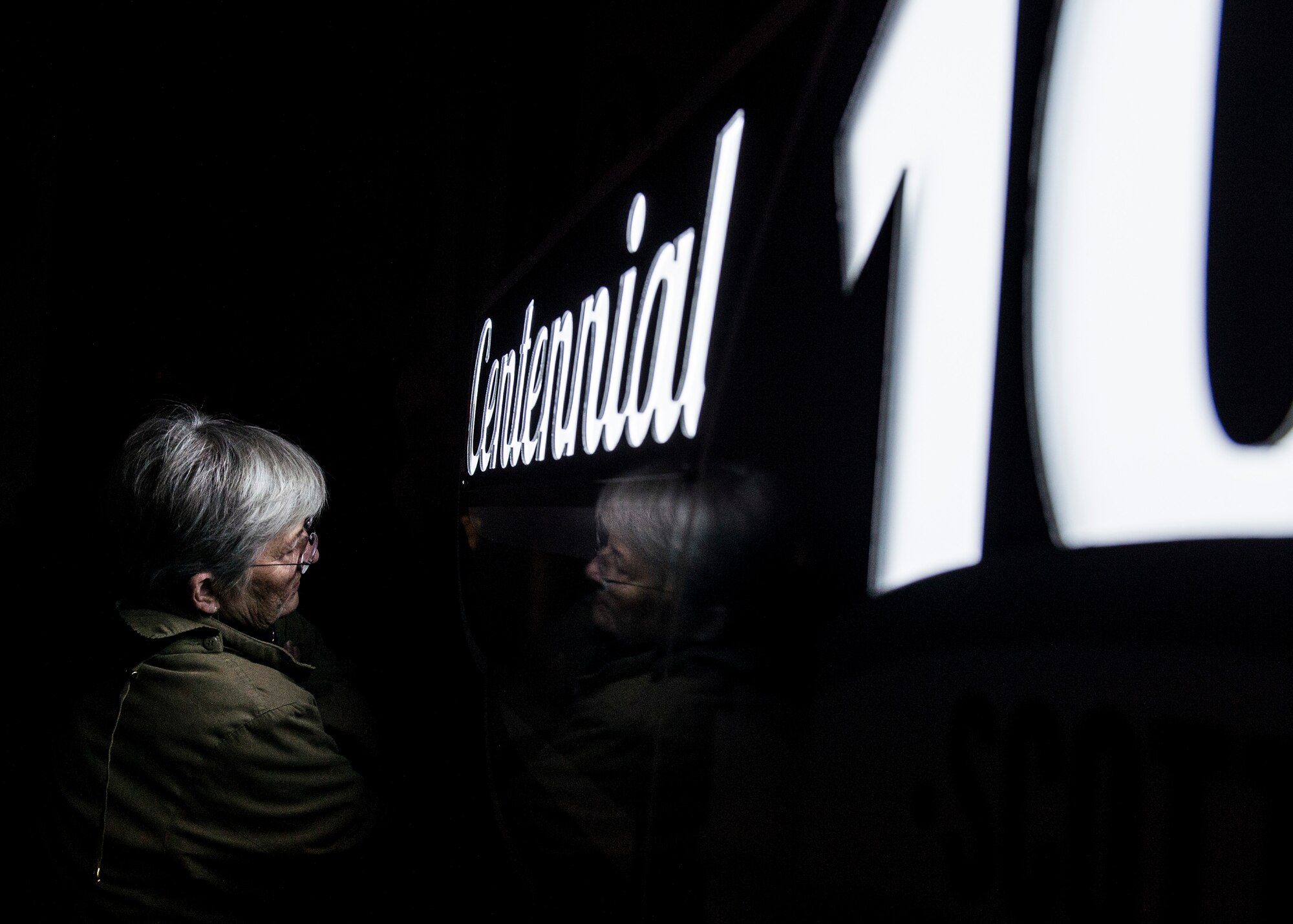 An attendee watches the fireworks at the end of the kickoff celebration next to the centennial signage at the Scott Event Center, Scott Air Force Base, Ill., Jan. 6, 2017. Over 500 people attended the celebration, which marked the beginning of events leading up to the largest public event this summer--the airshow and open house on June 10-11 featuring the USAF Thunderbirds. (U.S. Air Force photo by Staff Sgt. Jodi Martinez)