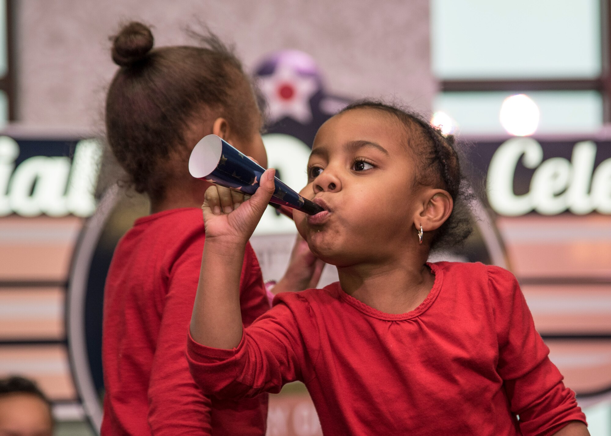Three-year-old Taegan Baggett, daughter of Staff Sgt. Justin Baggett and Staff Sgt. Corbyn Baggett, blows a kazoo during the Centennial celebration.  (U.S. Air Force photo by Senior Airman Tristin English)